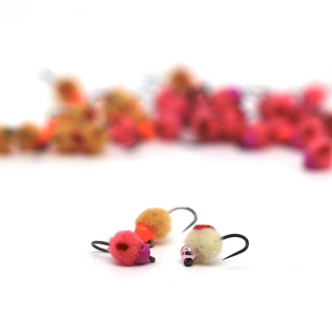 Tungsten egg fly assortment for trout fishing, shown with pink, orange, cream, and red egg patterns.